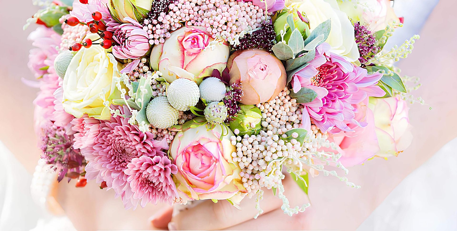 Nahaufnahme eines Brautstraußes, welcher von einer Braut gehalten wird.