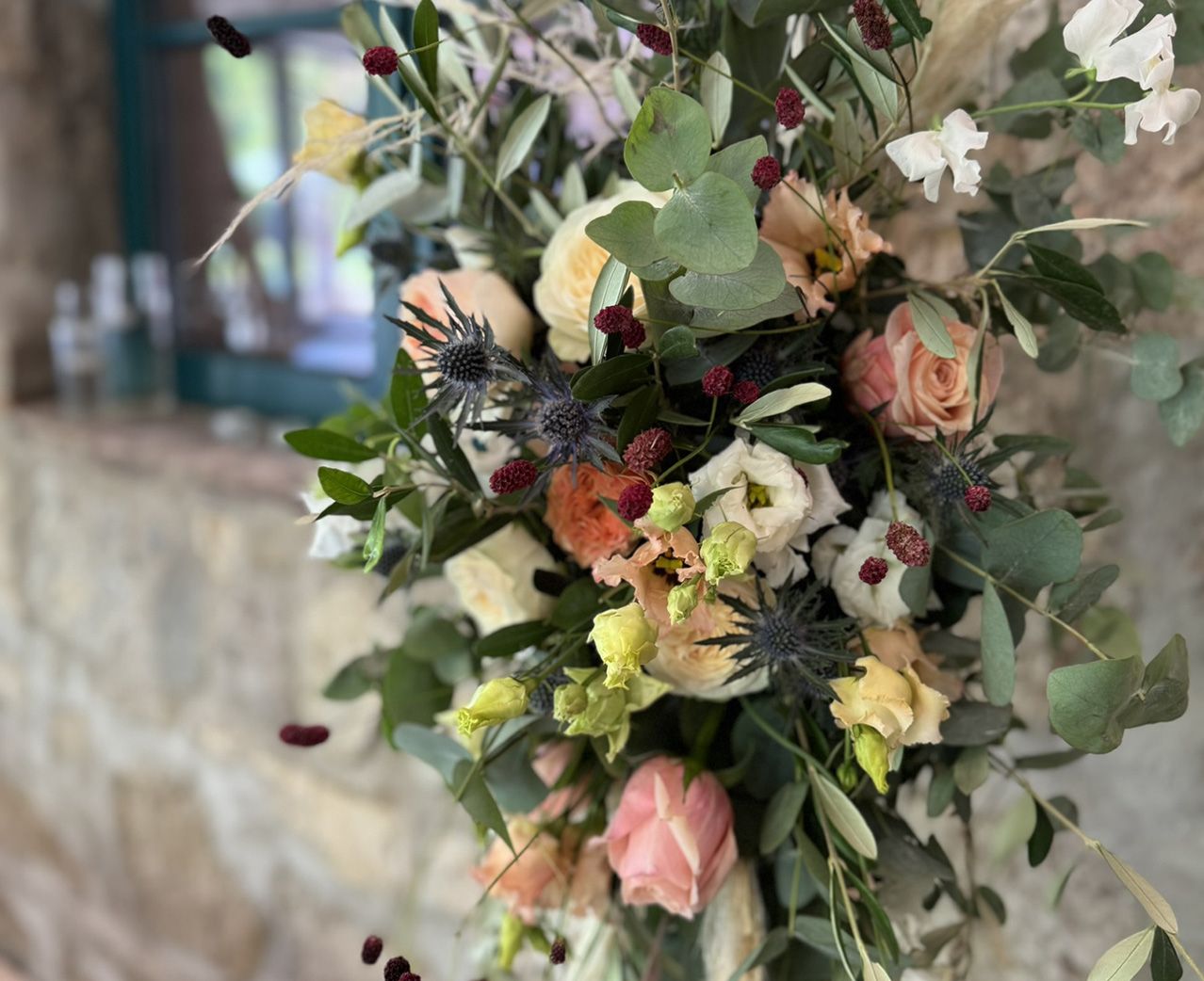 Ein Blumenstrauß hängt dekorativ an einer Wand, umgeben von sanften Farben und romantischer Atmosphäre.